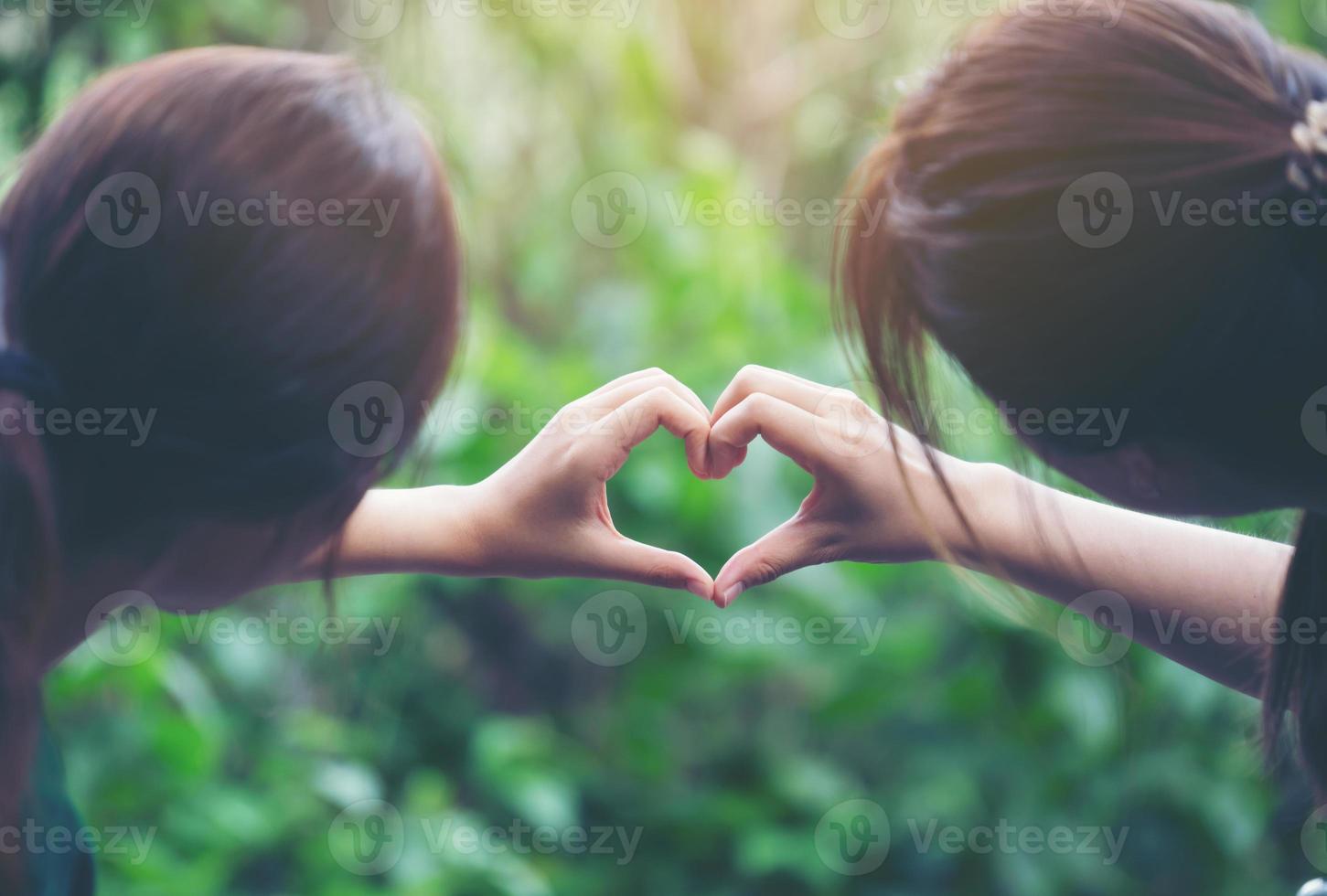 mujeres haciendo formas de corazón con sus manos foto