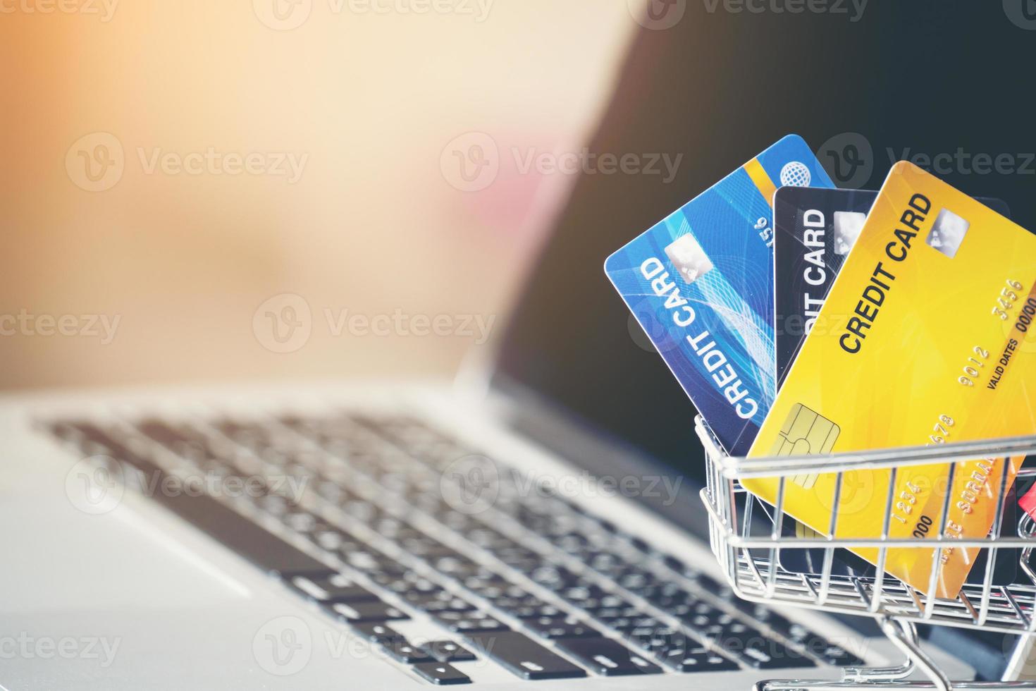 Shopping cart and credit card with laptop on the desk photo