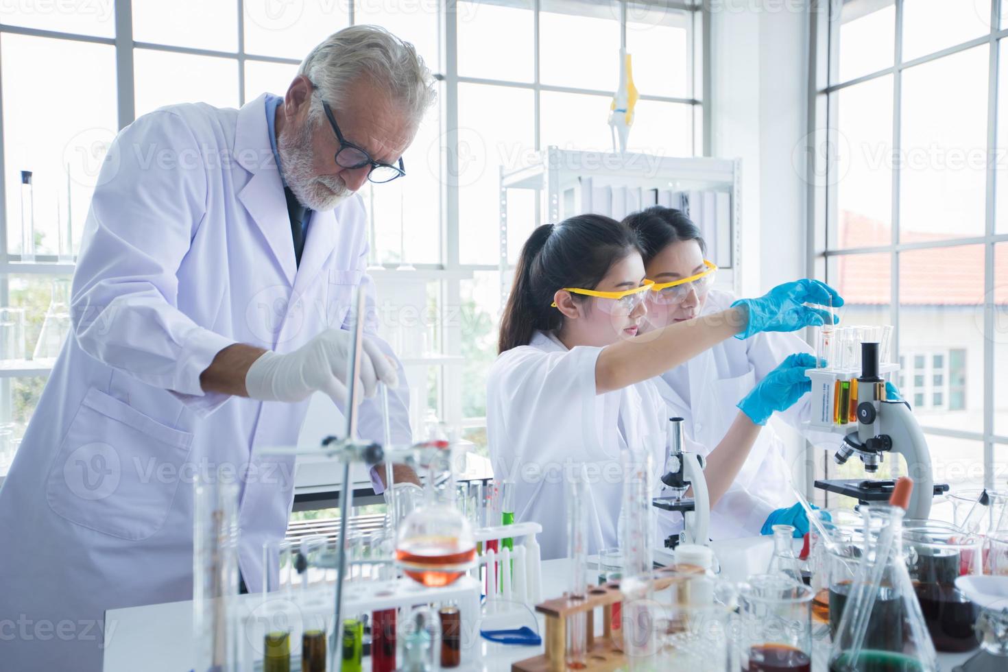 La investigación médica y los científicos están trabajando con un microscopio y una tableta y tubos de ensayo, micropipetas y resultados de análisis en un laboratorio. foto