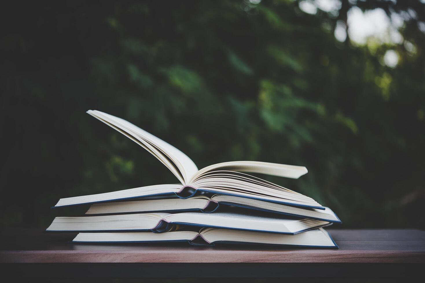 Open book on wooden table outdoors photo