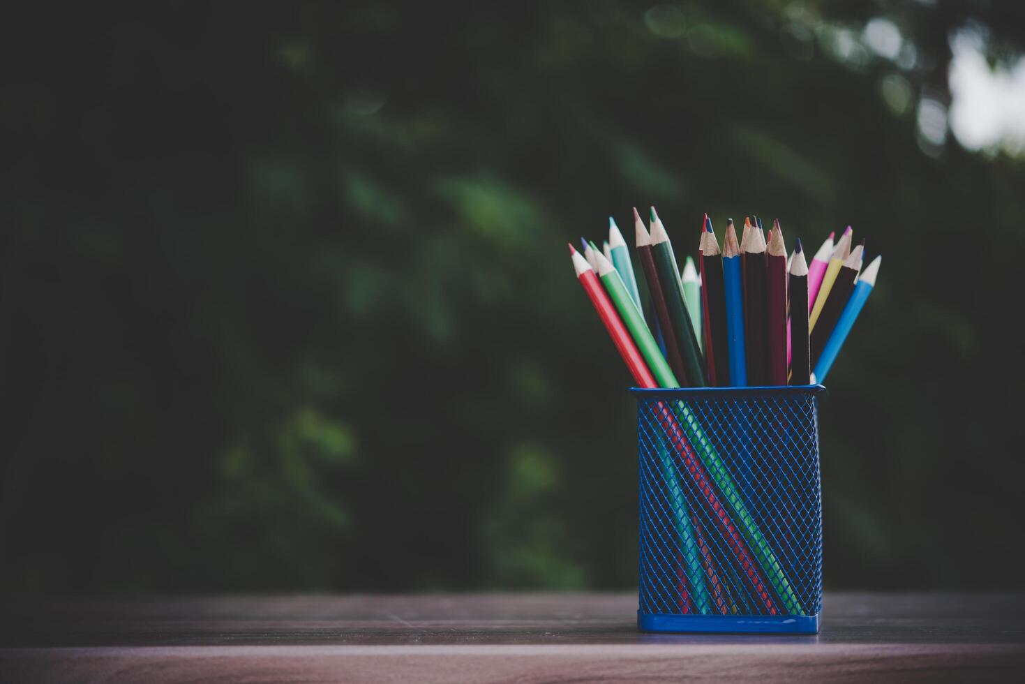 Lápices de colores sobre la mesa de madera con bokeh foto