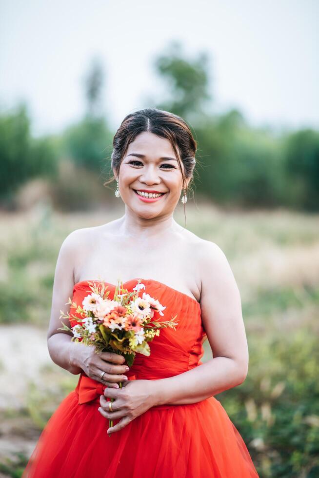 Beautiful bride in wedding dress posting in the nature photo