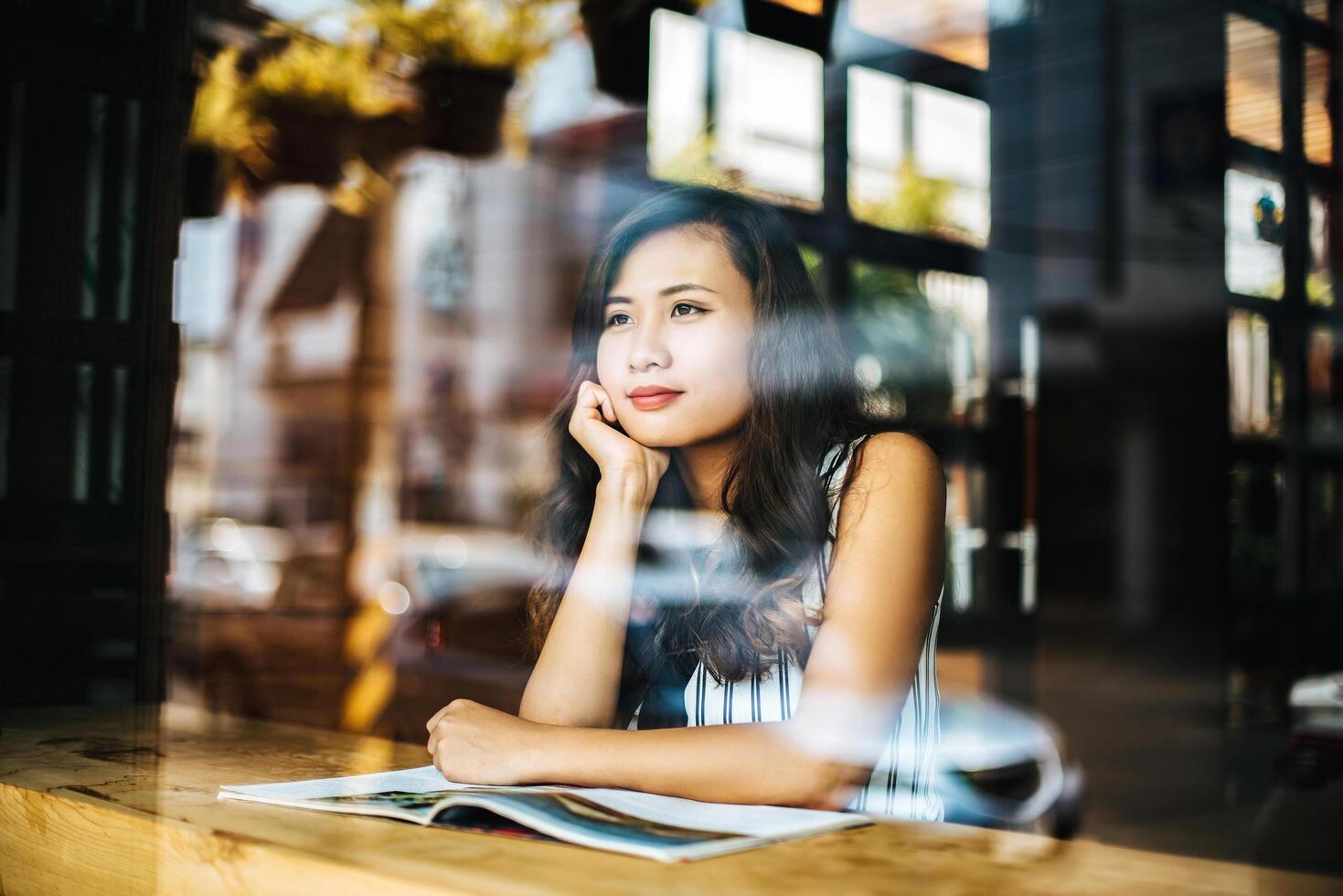 Hermosa mujer leyendo una revista en el café foto