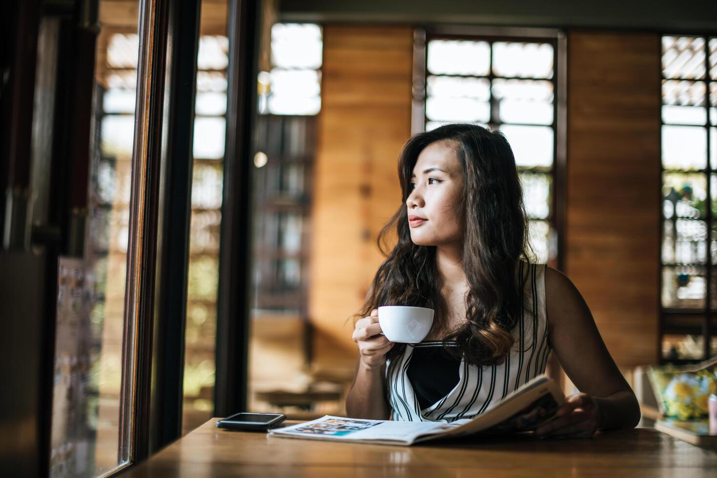 Beautiful woman reading magazine in cafe photo