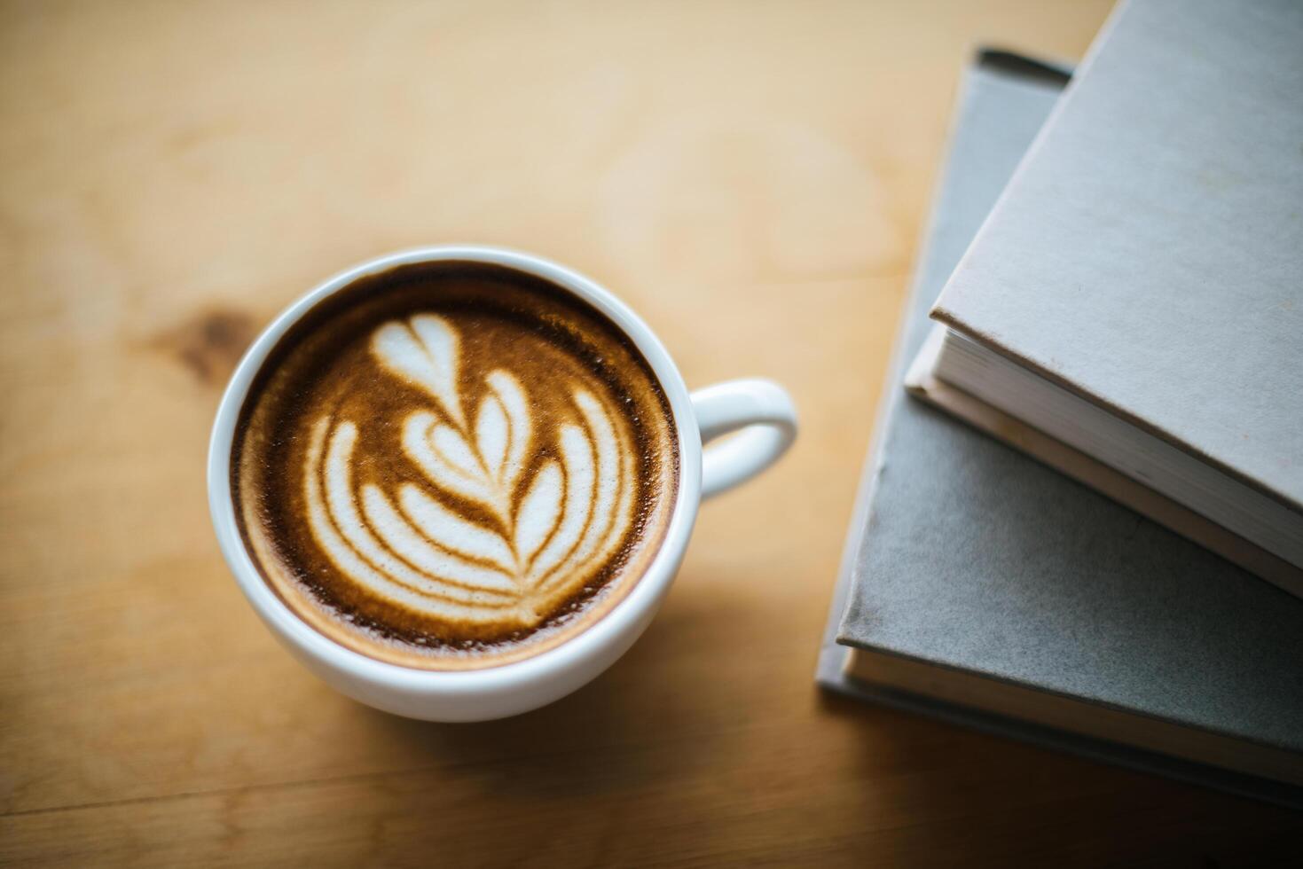 Latte art in coffee cup on the cafe table photo