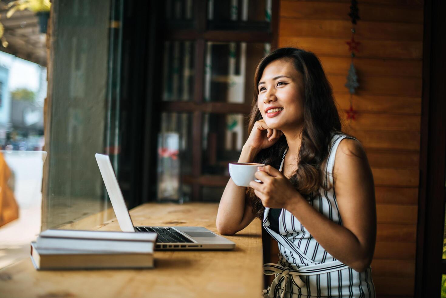 Beautiful woman working with laptop computer at coffee shop cafe photo