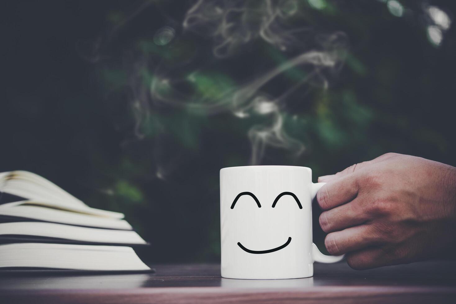 hand holding coffee cup on wood table photo