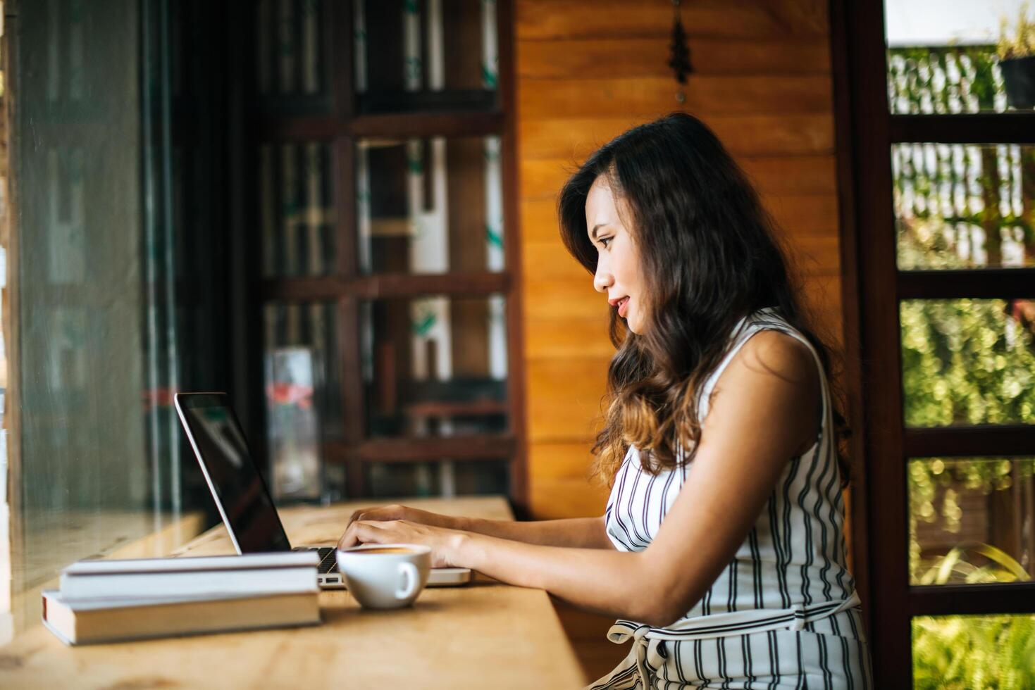 Beautiful woman working with laptop computer at coffee shop cafe photo