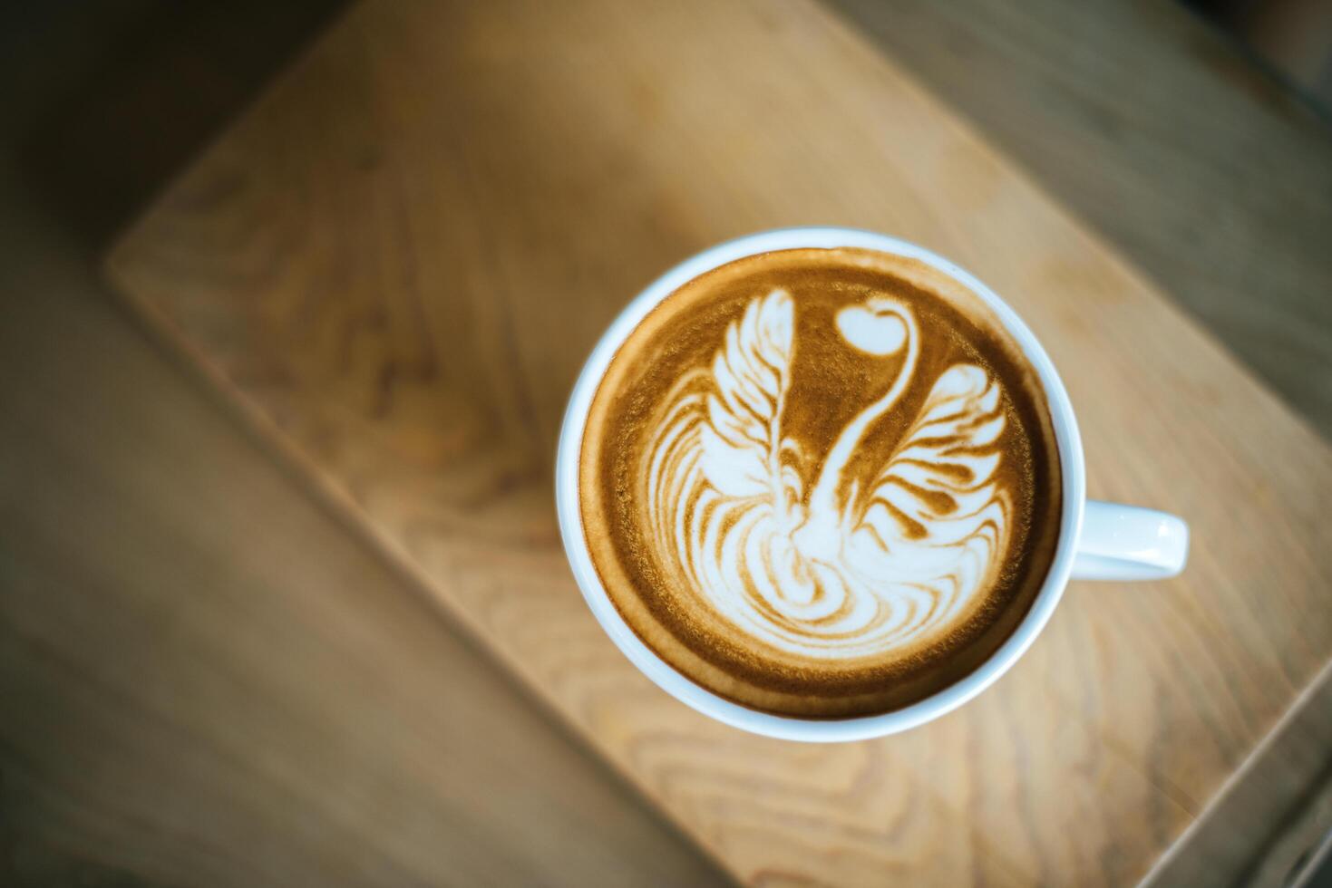 Latte art in coffee cup on the cafe table photo