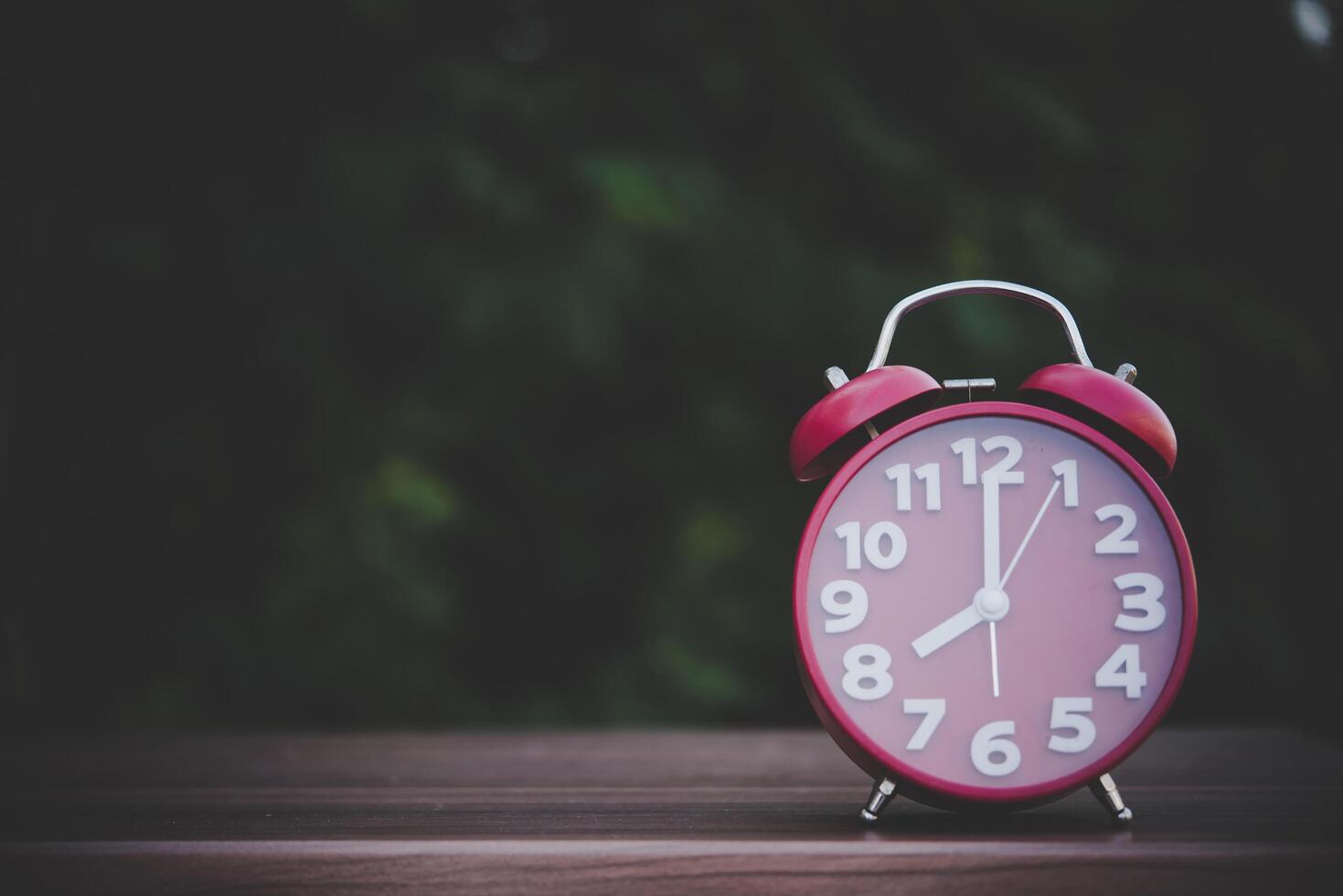 Alarm clock on wooden with green background photo