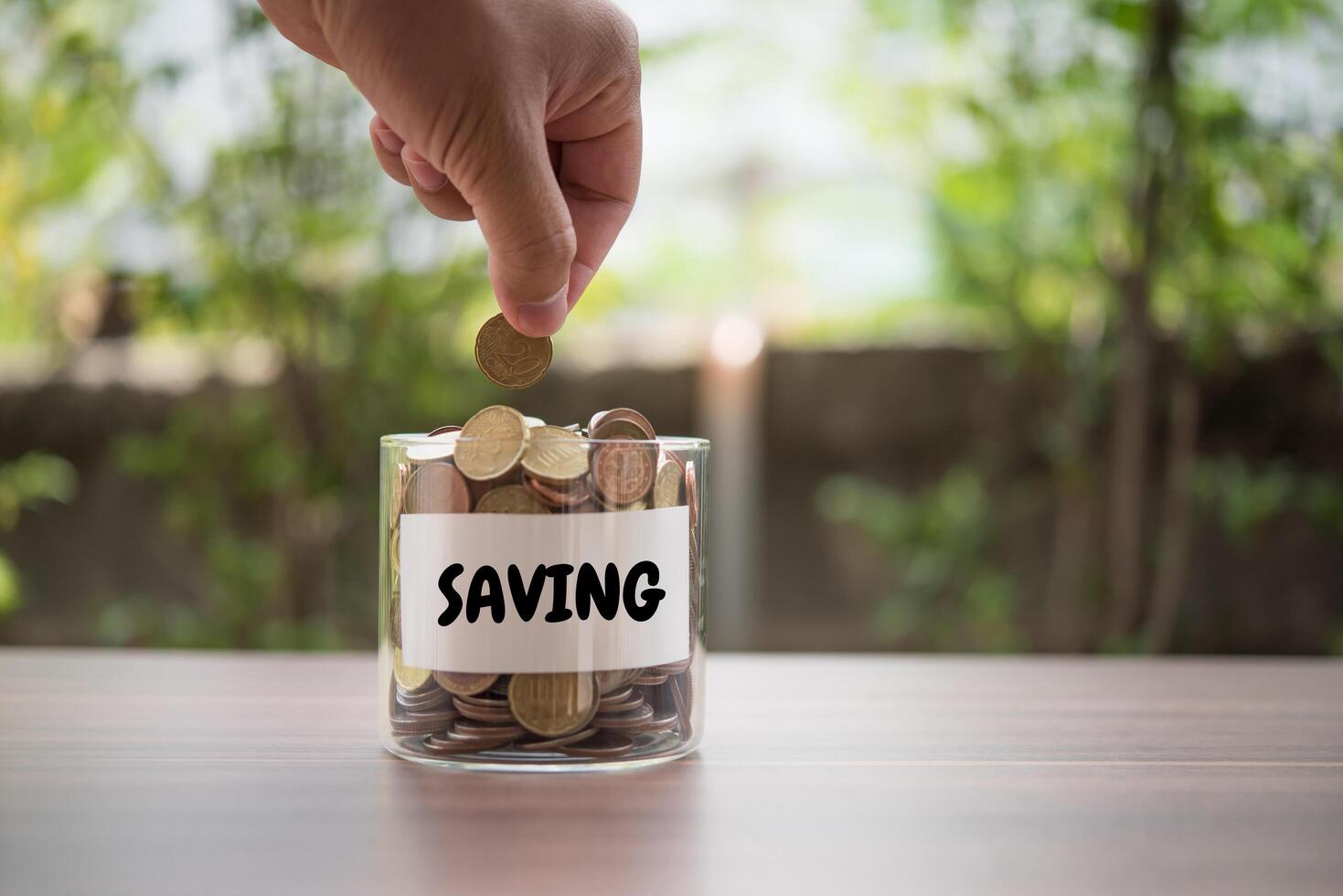 Hand  putting coins in jar with money stack step growing growth saving money photo