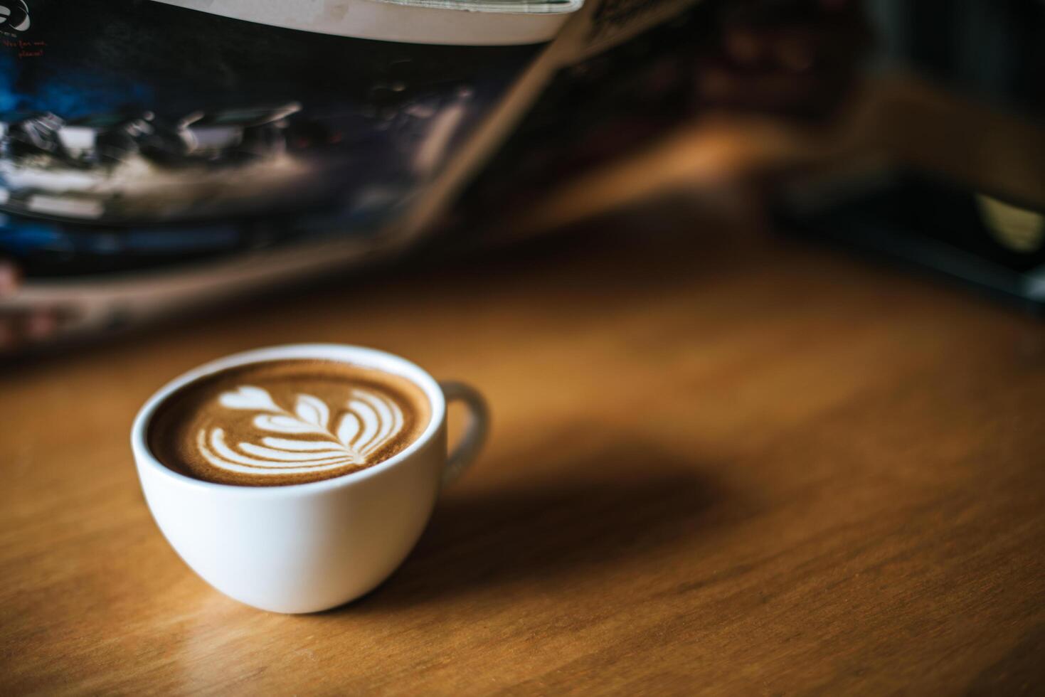 Latte art in coffee cup on the cafe table photo