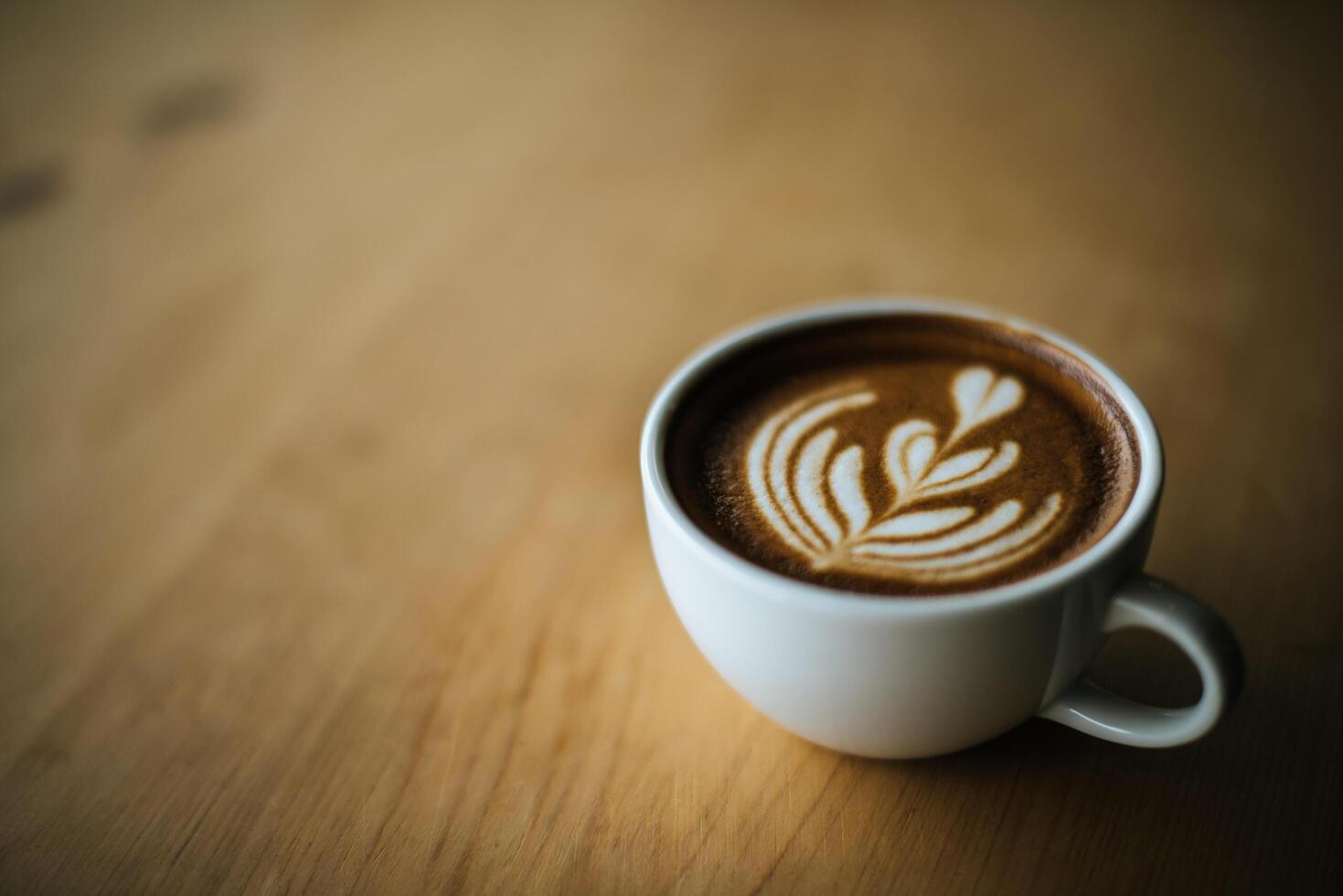 Latte art in coffee cup on the cafe table photo