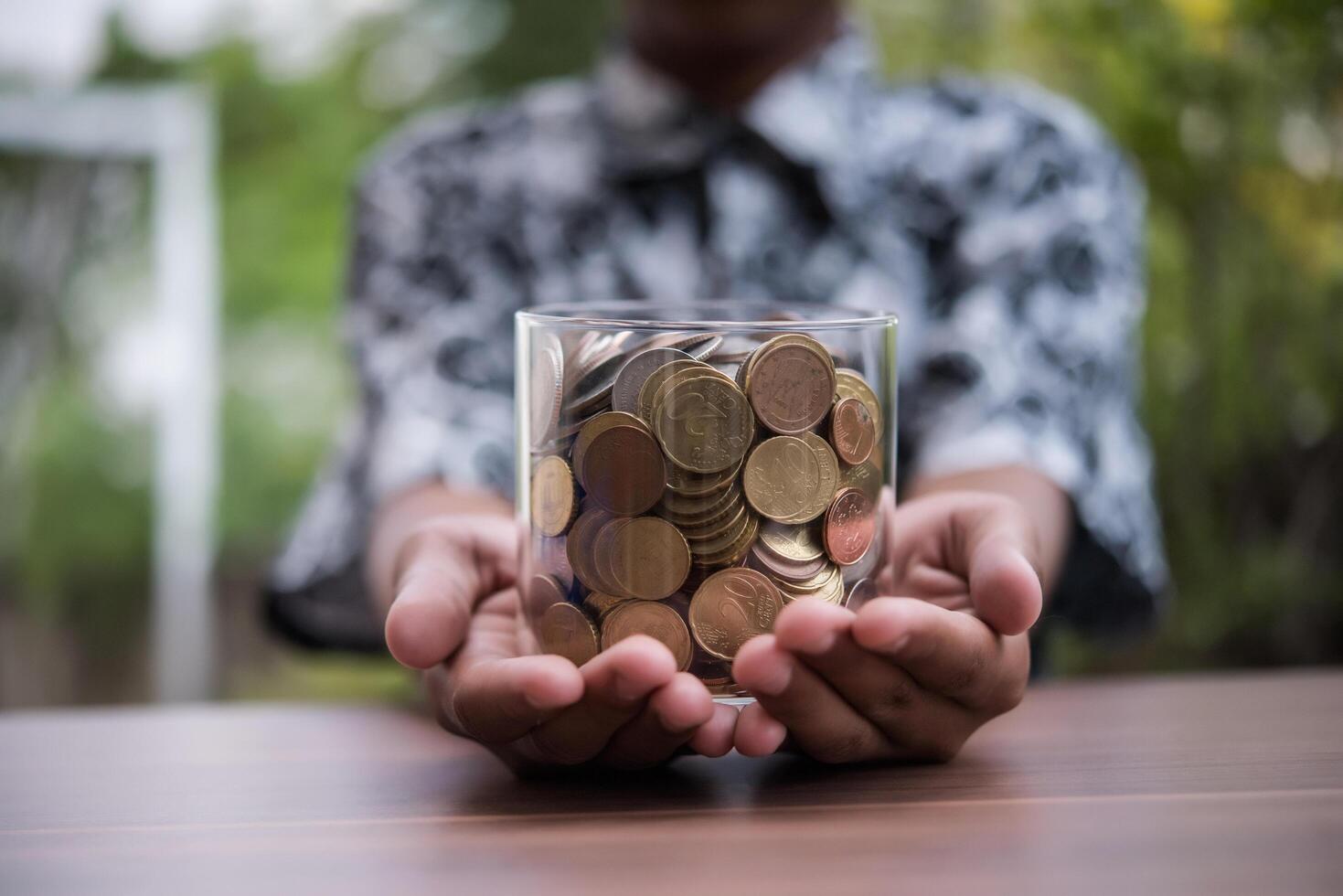 Hand  putting coins in jar with money stack step growing growth saving money photo