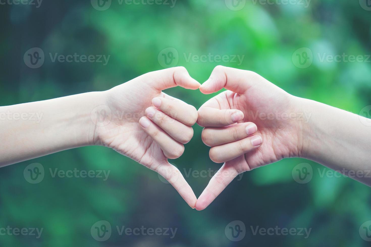 women making heart shapes with their hands photo