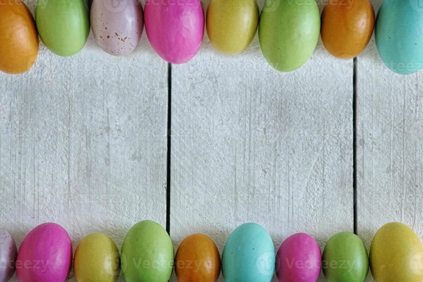 Pascua o primavera fondo temático de madera vieja y huevos de colores alineados foto