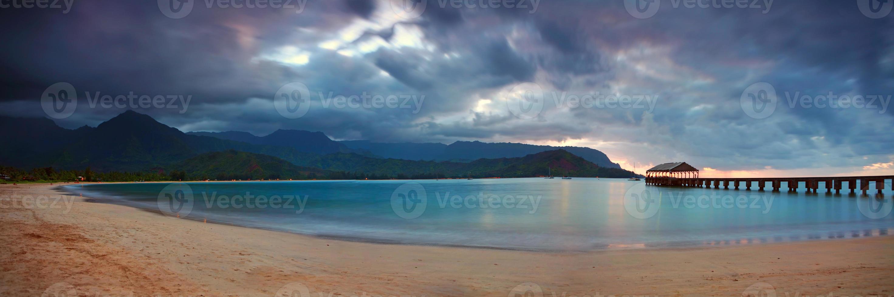 muelle hawaiano al atardecer con nubes dramáticas foto