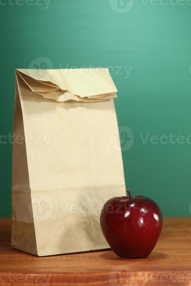 Saco de almuerzo escolar sentado en el escritorio del profesor foto