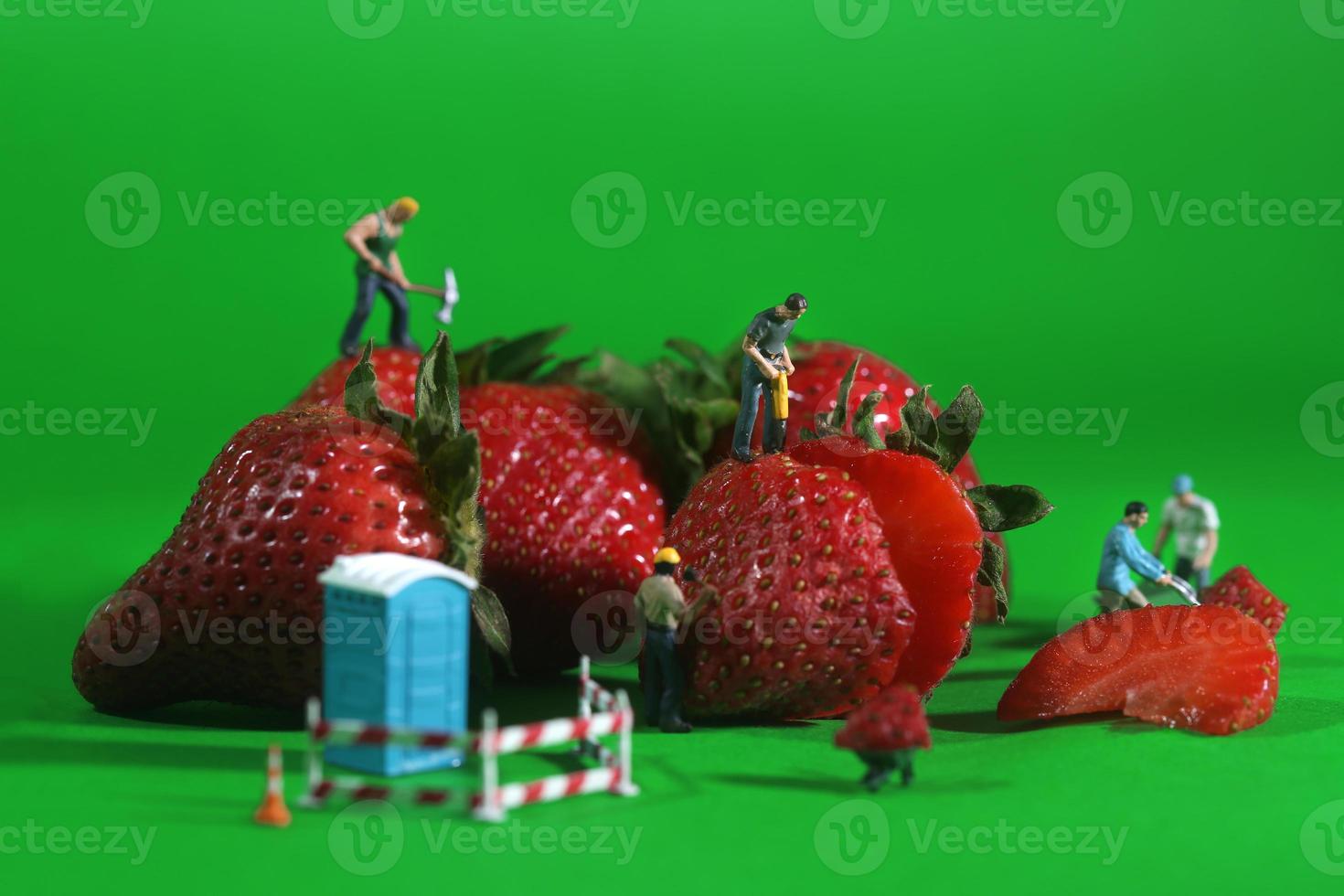 Trabajadores de la construcción en imágenes conceptuales de alimentos con fresas foto