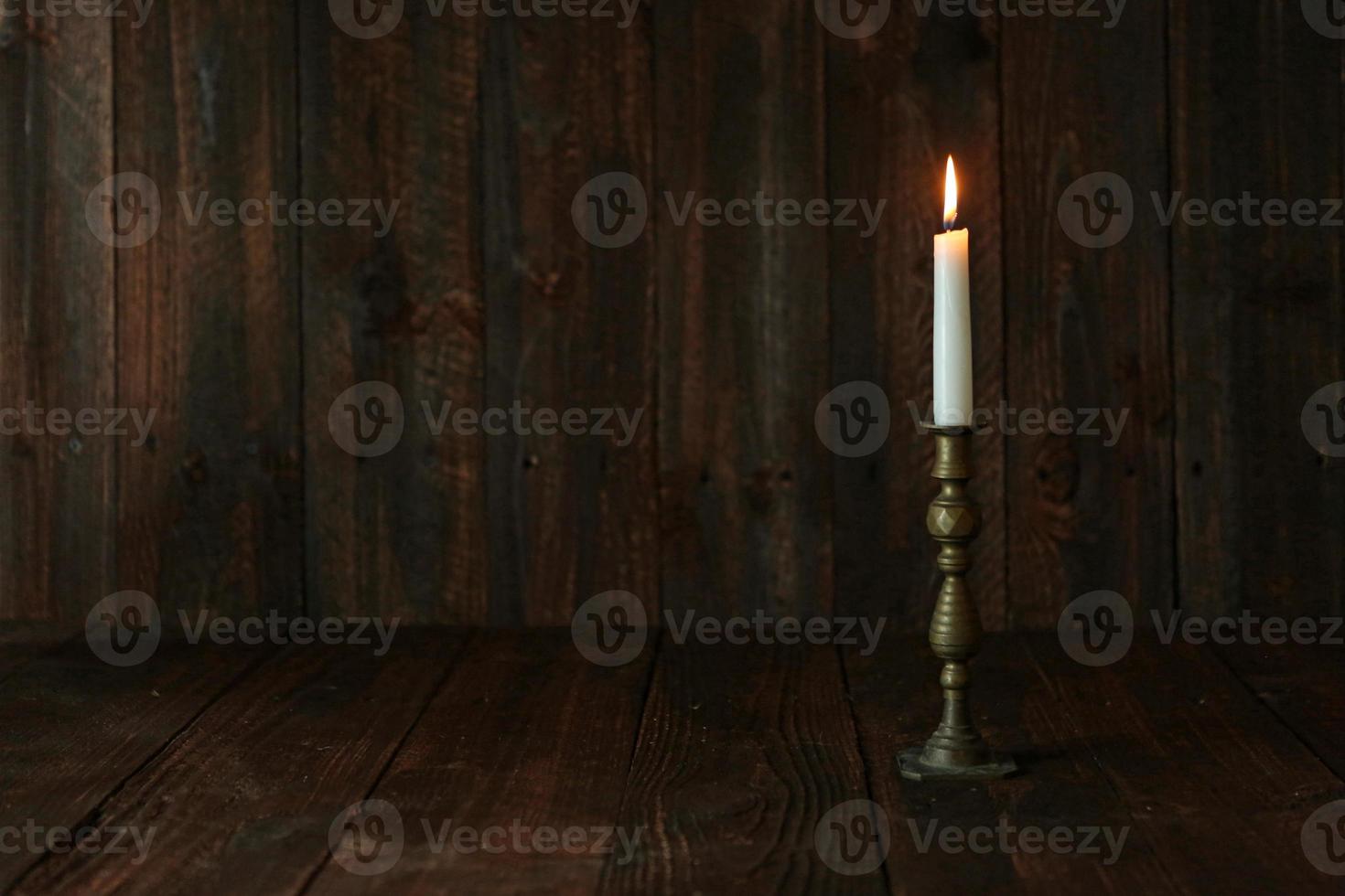 Vela encendida sobre un fondo rústico de madera vieja foto