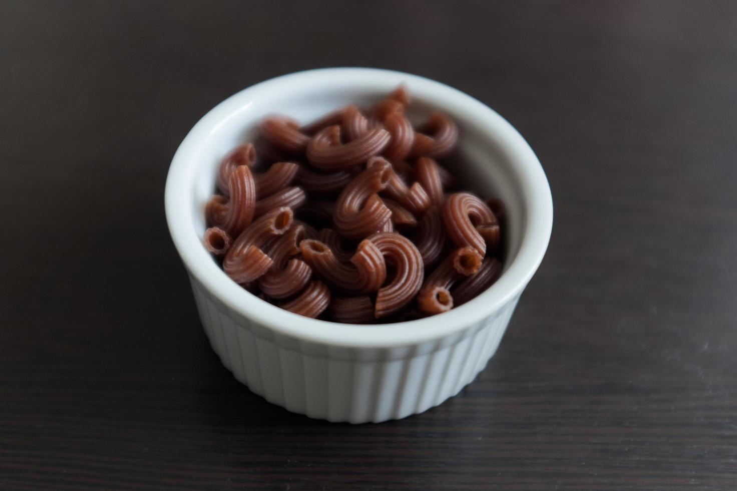 pasta penne seca orgánica cruda lista para cocinar. alimentos orgánicos foto