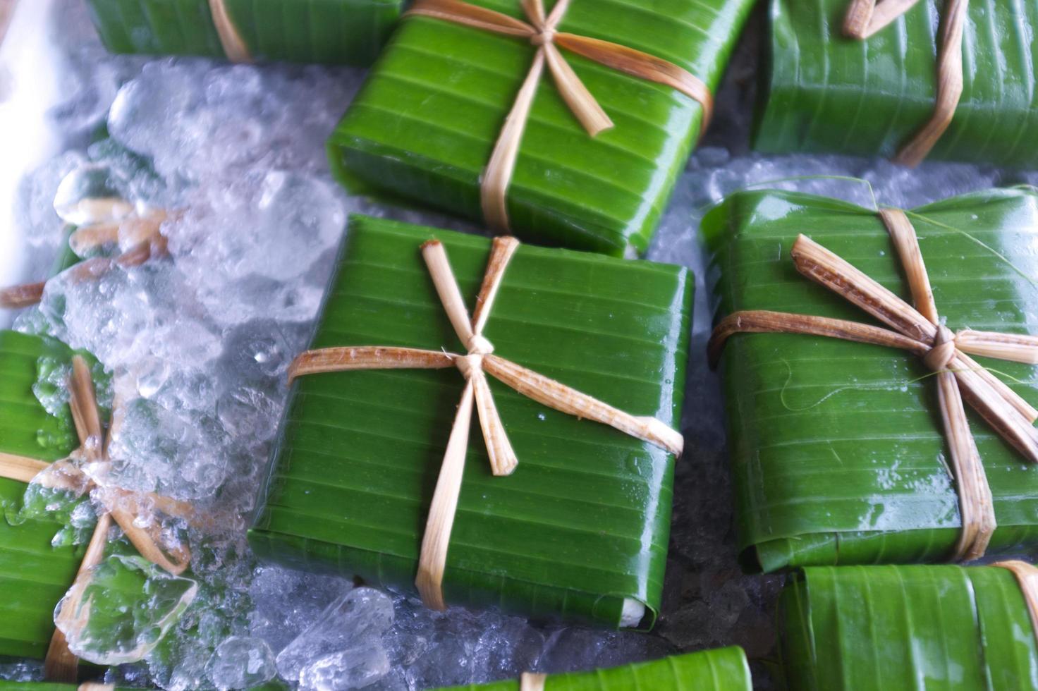 Envases de estilo tailandés tradicional, tofu casero envuelto en hoja de plátano con hilo natural foto