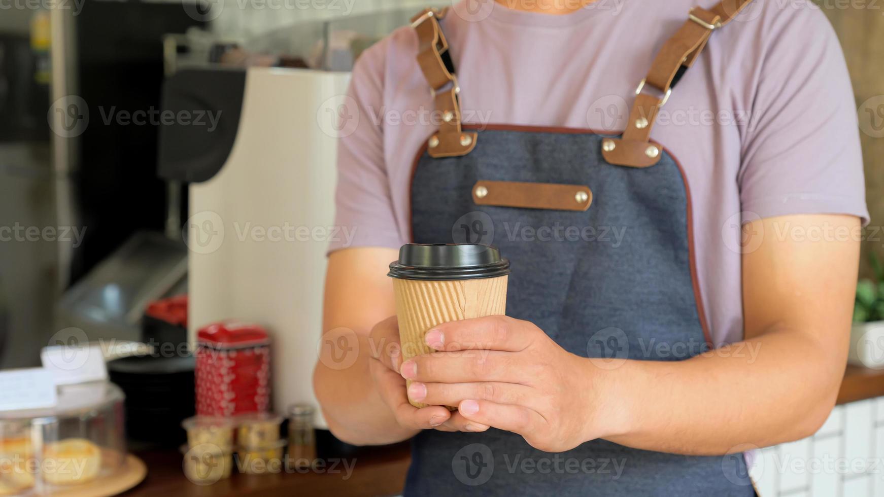 Barista hold a take away coffee mug send to customers. photo