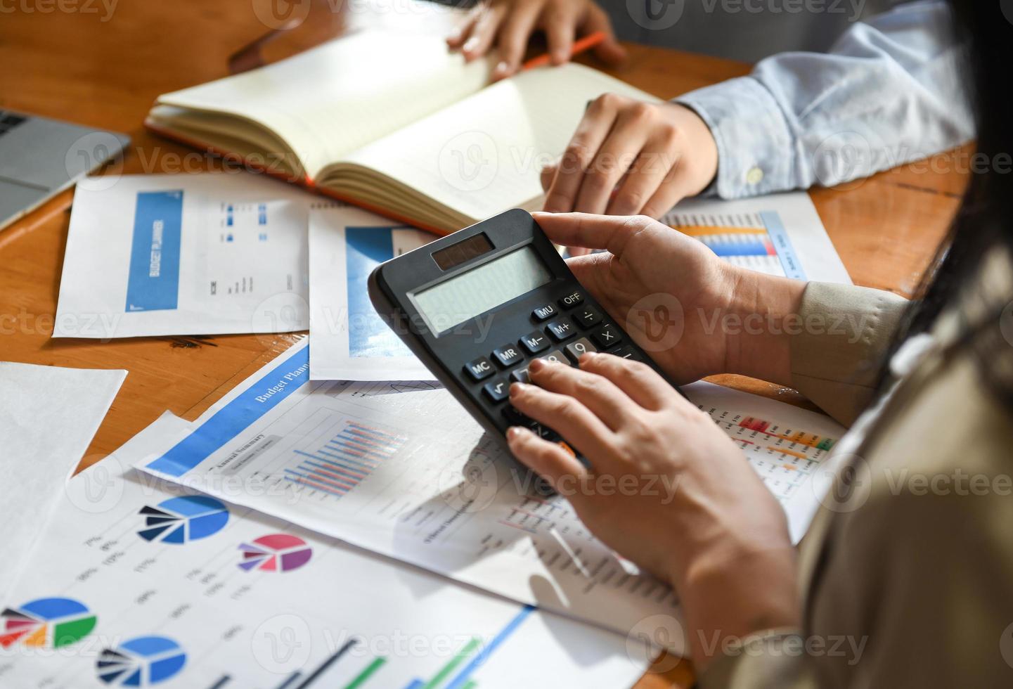 The accounting team is using the calculator in the office. photo