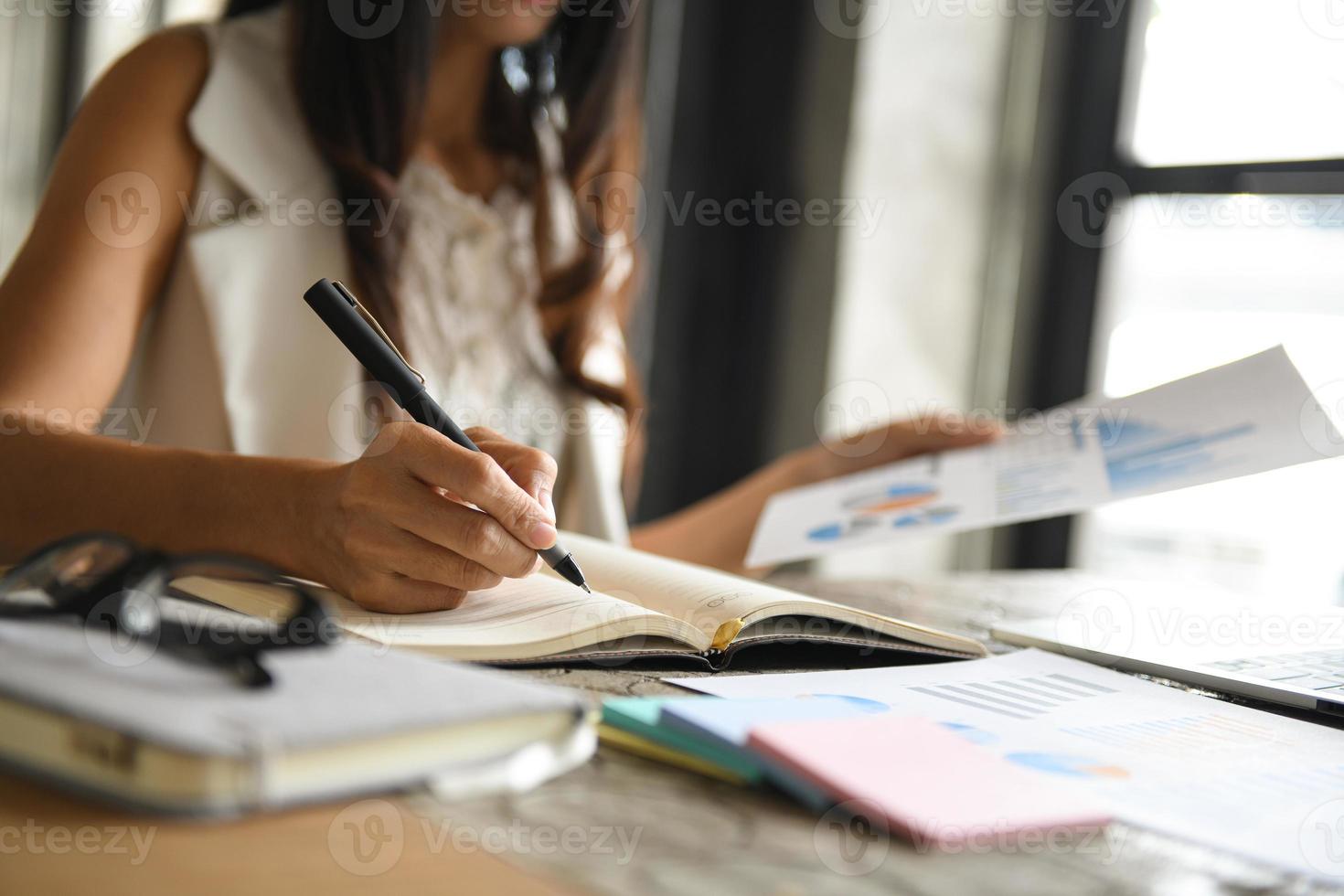 Executives are checking data from graphs and taking notes. photo