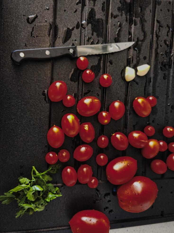 cherry tomatoes, garlic and parsley in Italian cuisine ready to be tasted and eaten photo