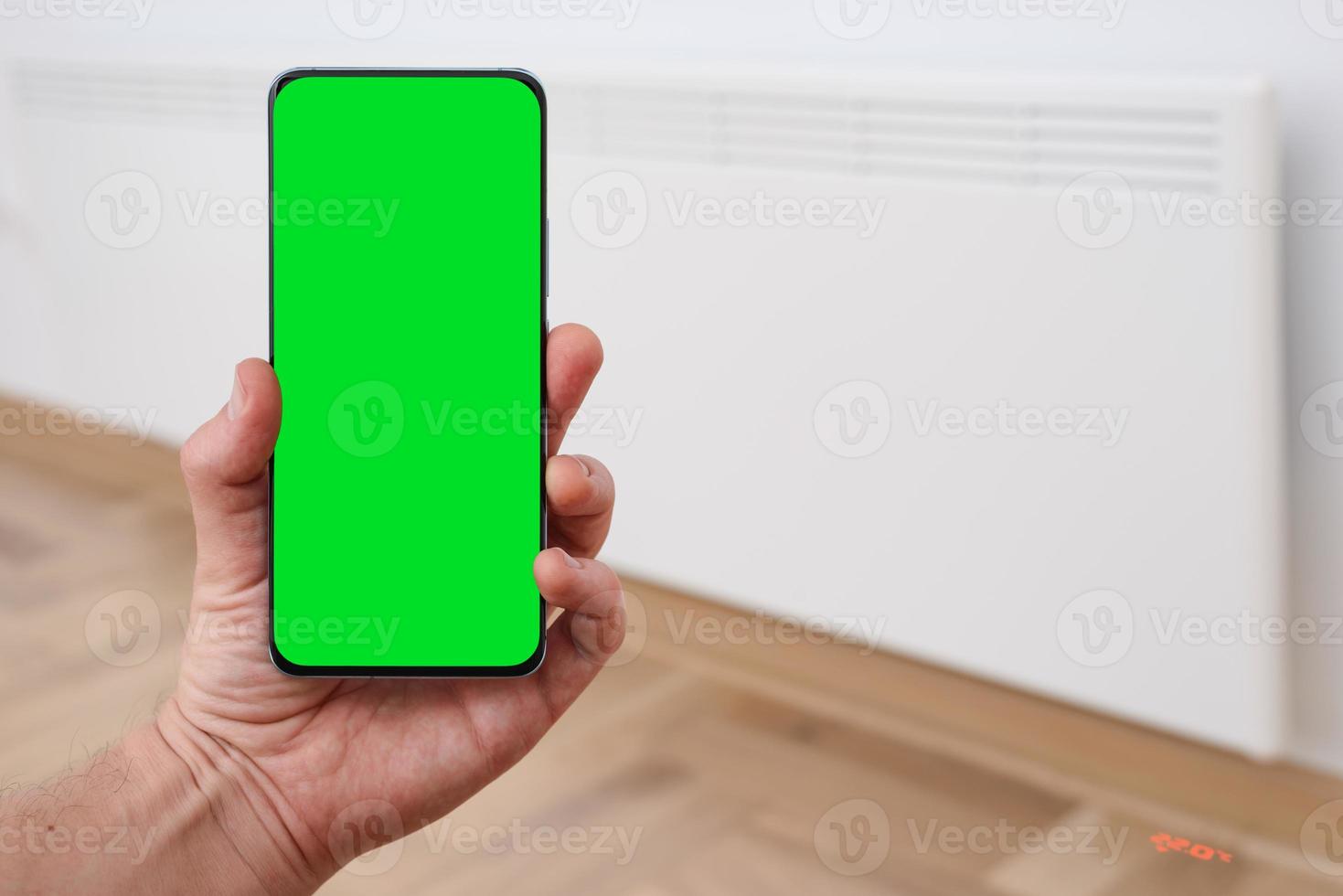 Smart heater convector control by phone app. Smart Home with the smart heating system. Electric panel heating concept. Chroma key, green screen. photo