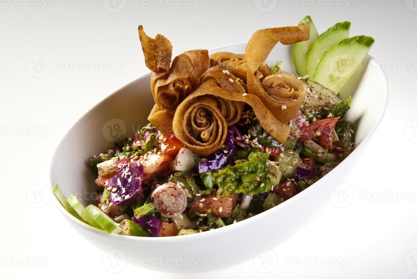 Delicious Fattoush or Arab salad with pita croutons, fresh vegetables and herbs, on white plate. Middle Eastern bread salad. Easy and healthy authentic recipe photo