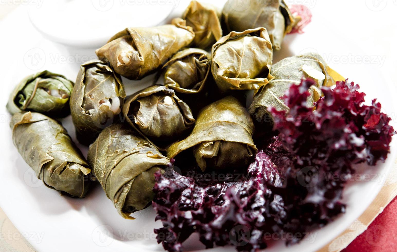 un plato de deliciosas hojas de parra rellenas con guarnición de perejil foto