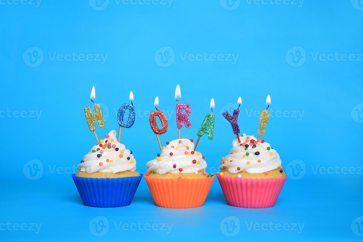 cupcakes de cumpleaños con velas que dicen hurra foto