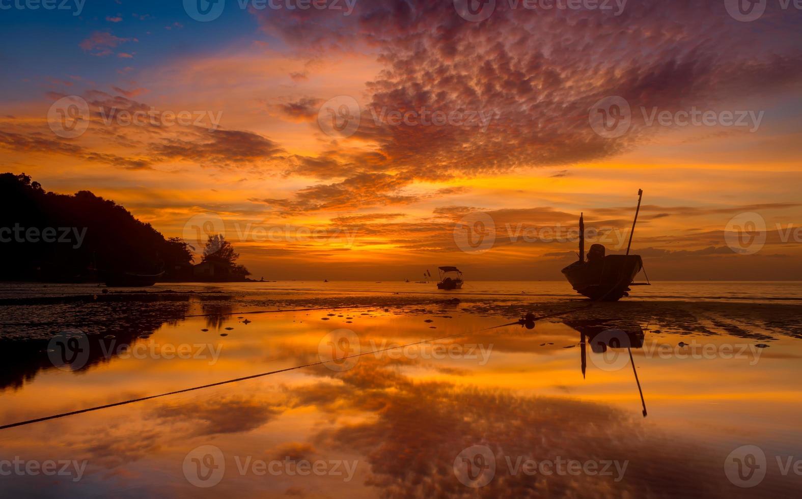 barcos de pesca de silueta en la puesta del sol. foto