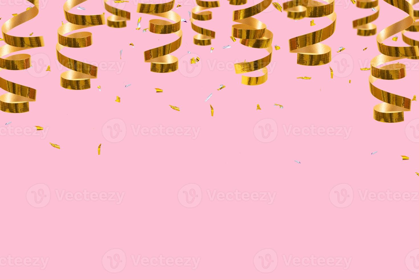Golden shiny spirals, streamers and confetti on a red background with place for text. Festive christmas background photo