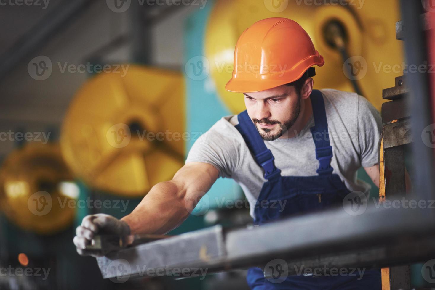 retrato de un joven maestro que trabaja en una fábrica. foto