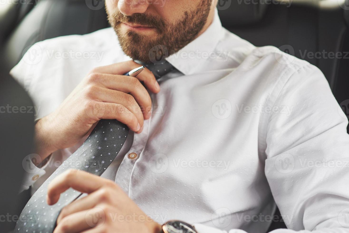 A beautiful young man is preparing to meet in full suit. photo