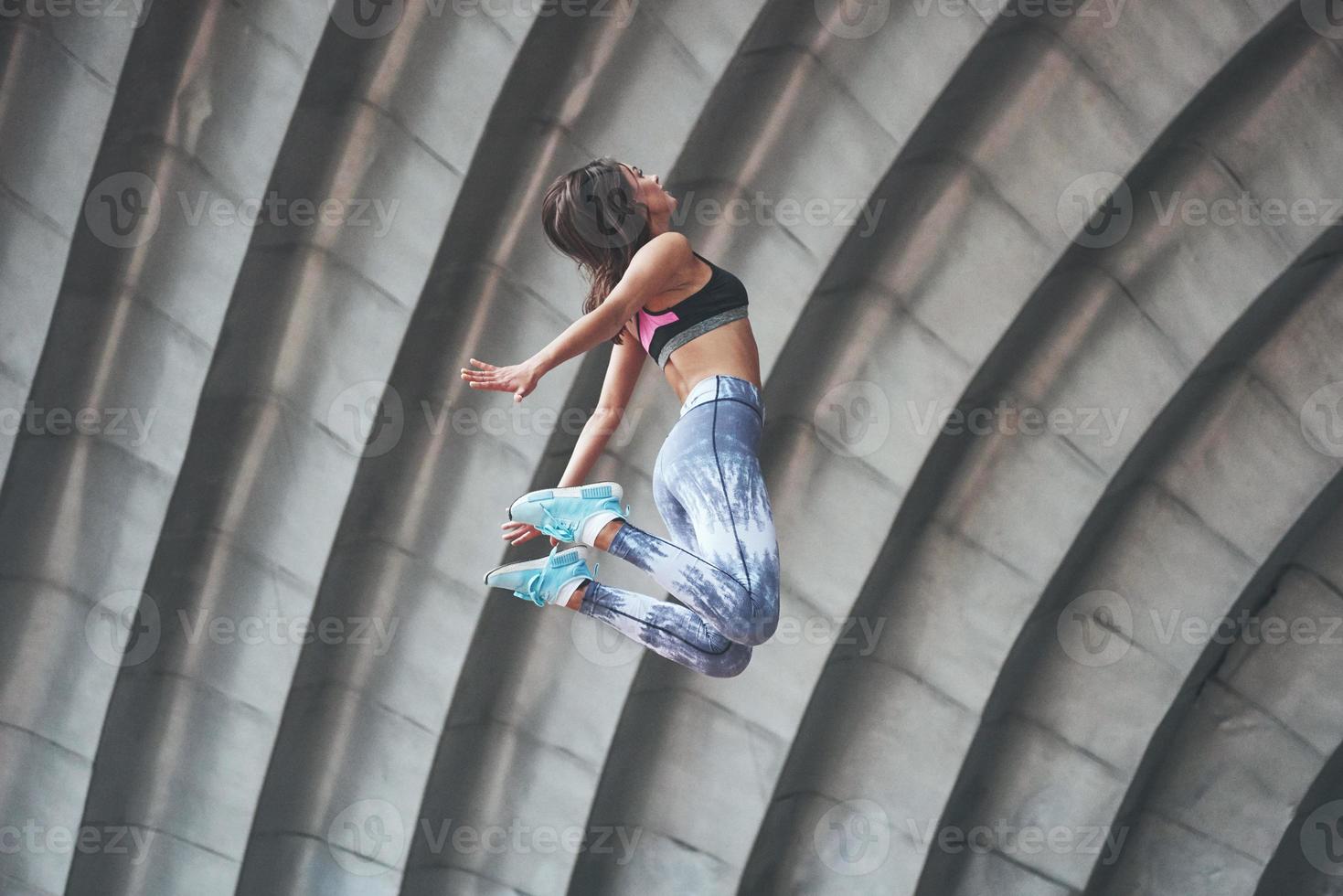 Woman doing parkour in the city on a sunny day. photo