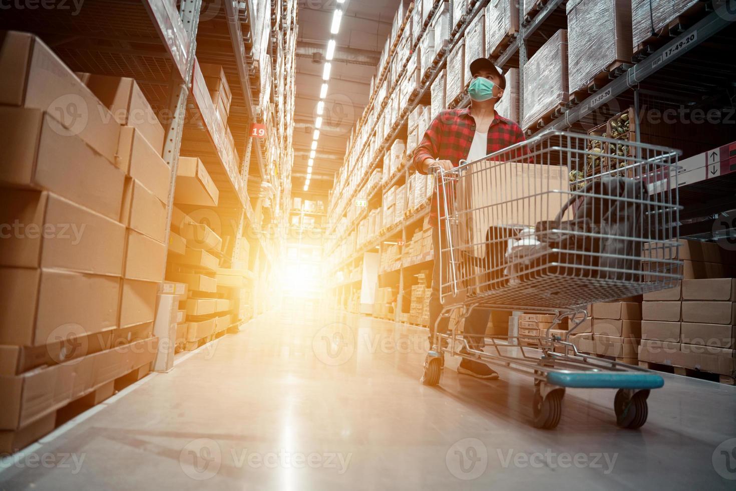 The young man wears a mask shopping in the warehouse store photo