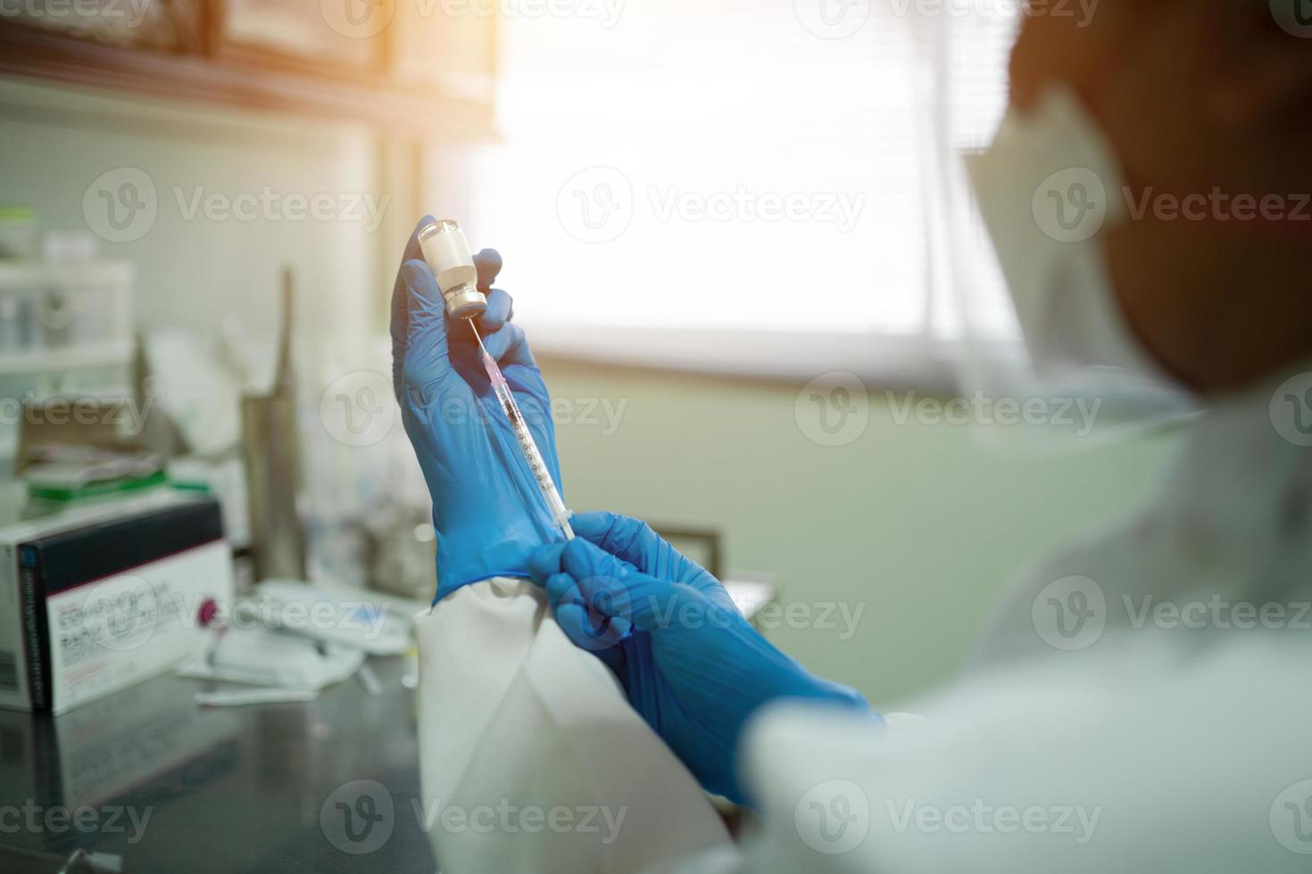 el médico está sacando una vacuna con jeringa de un frasco. antes de la vacunación para desarrollar la inmunidad del cuerpo contra el coronavirus. foto