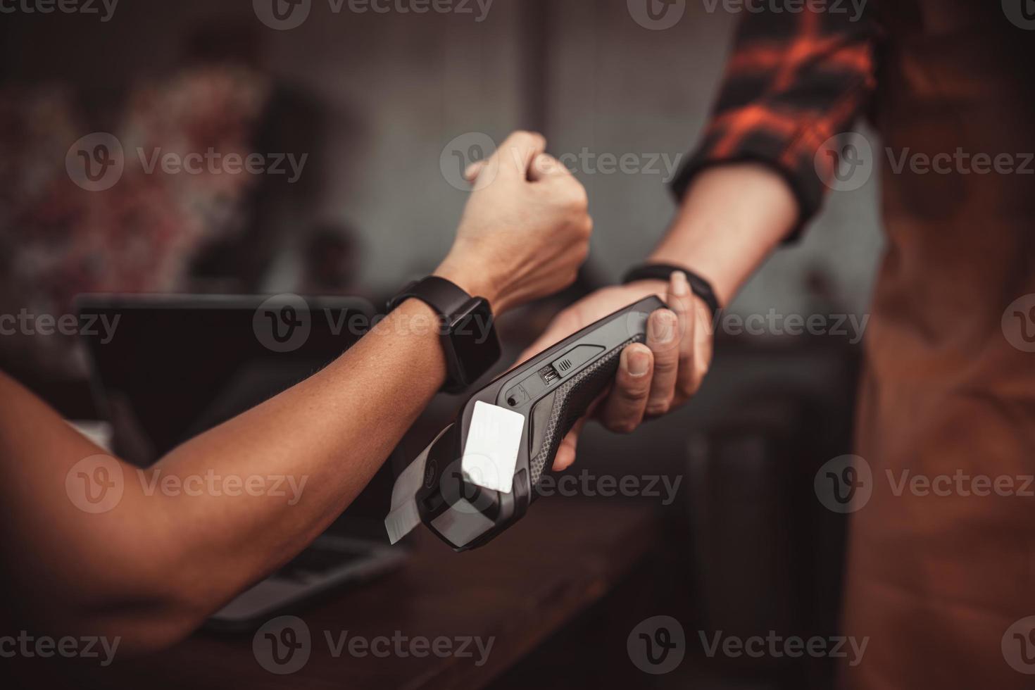 Pago SmartWatch con lector de tarjetas de crédito en el café de la máquina foto