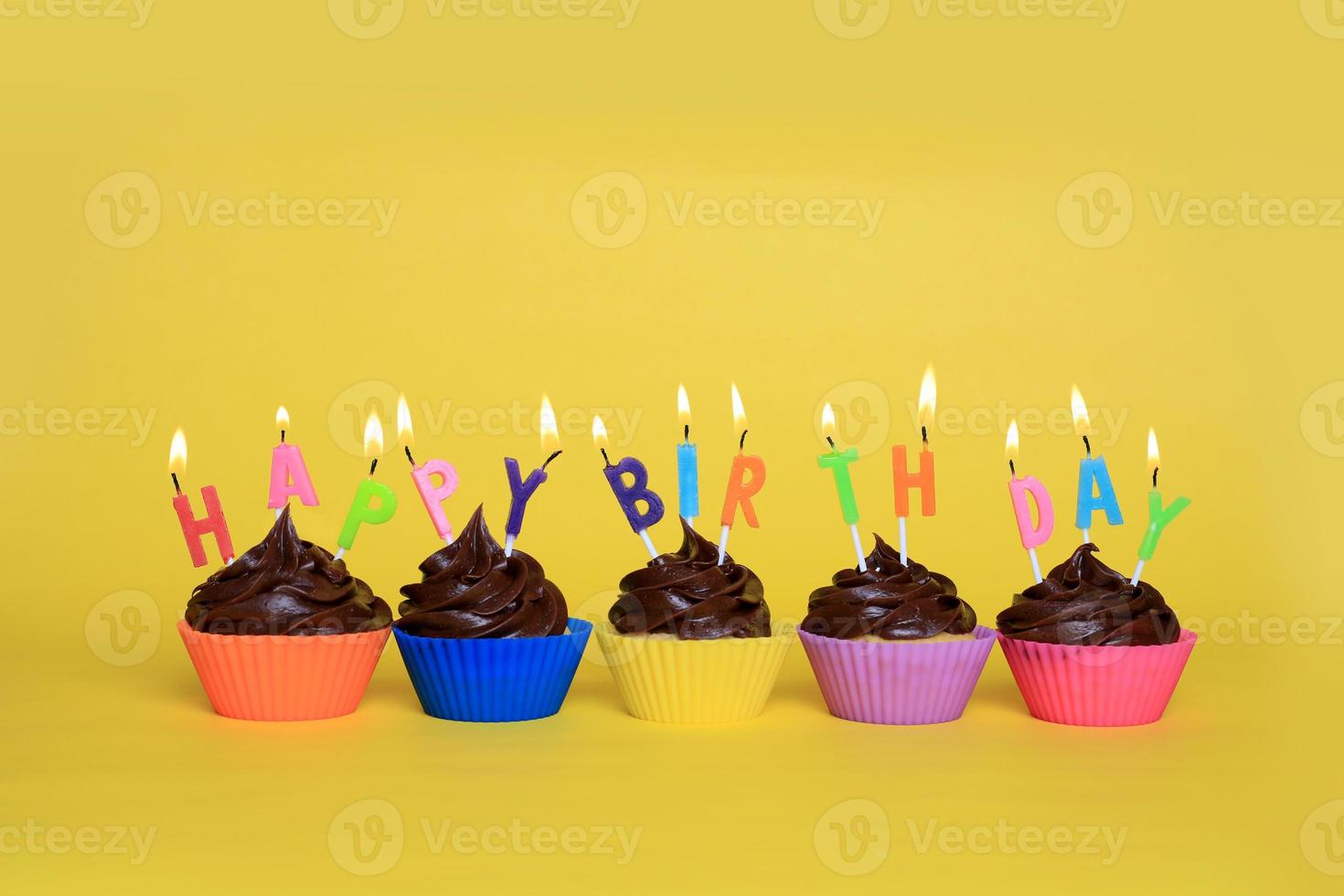 coloridos cupcakes de feliz cumpleaños con velas foto