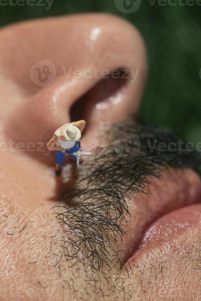 Little People Mowing Hair off a Mans Face photo