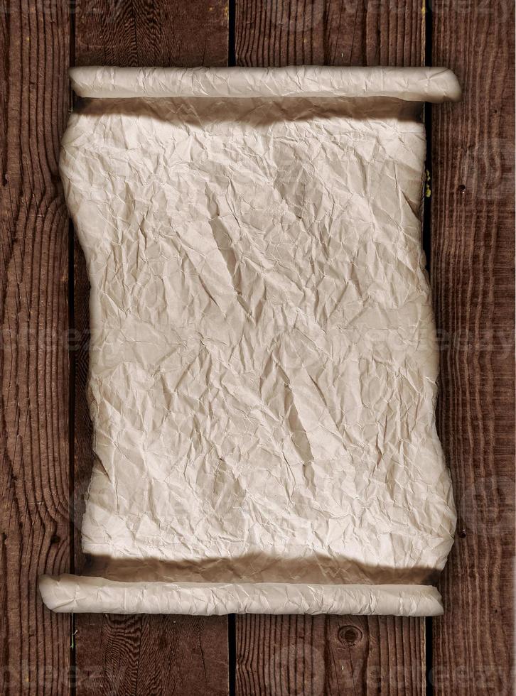 Worn Parchment Paper On a Wooden Rustic Background photo