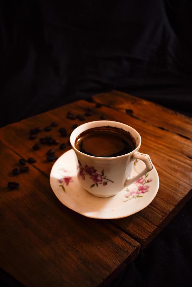 Cup of coffee and beans on an old wooden table photo