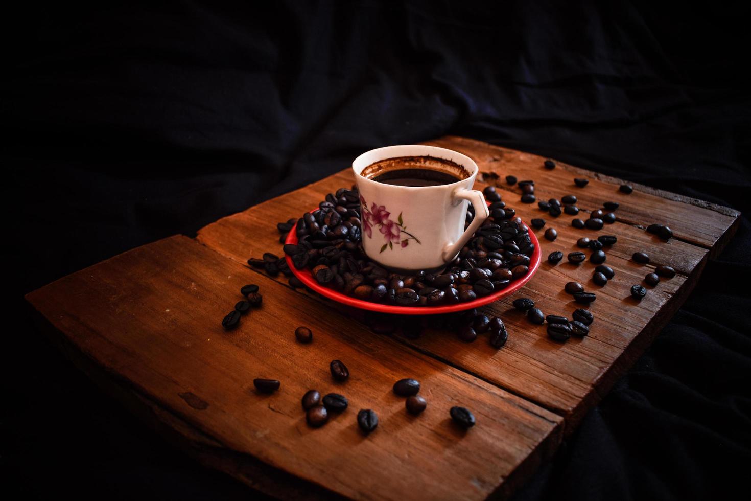 Cup of coffee and beans on an old wooden table photo