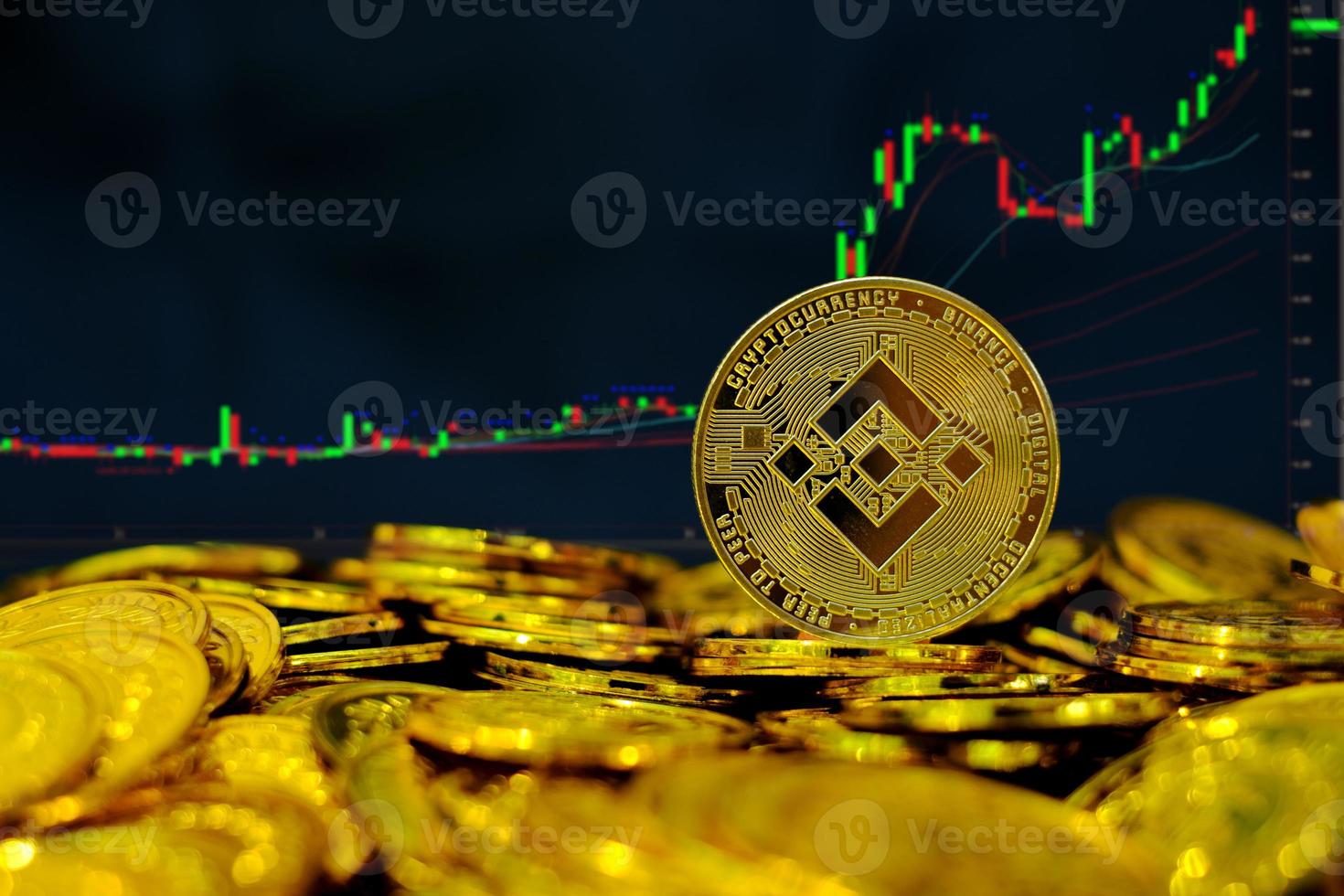 criptomoneda binance coin en la pila de monedas de oro en el fondo del gráfico de comercio de computadora foto