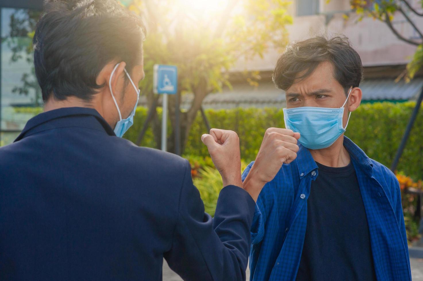 amigos se dan la mano con el codo nuevo normal para prevenir el coronavirus covid19 foto