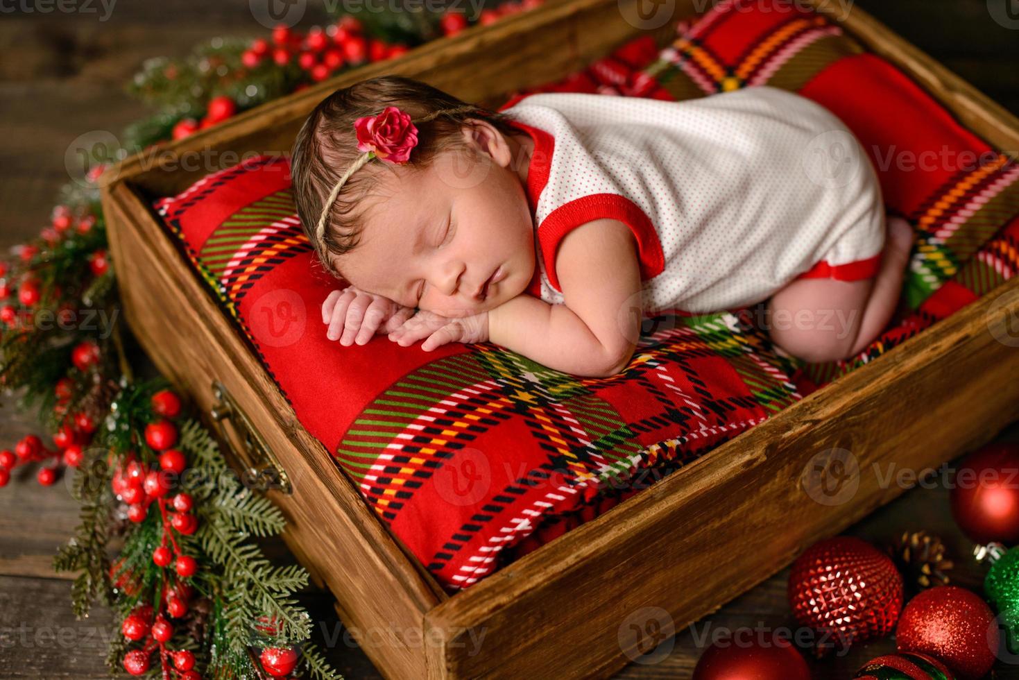 Little newborn girl eight days old in Christmas suit photo